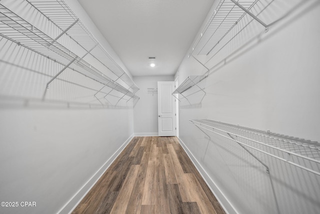 walk in closet with wood finished floors