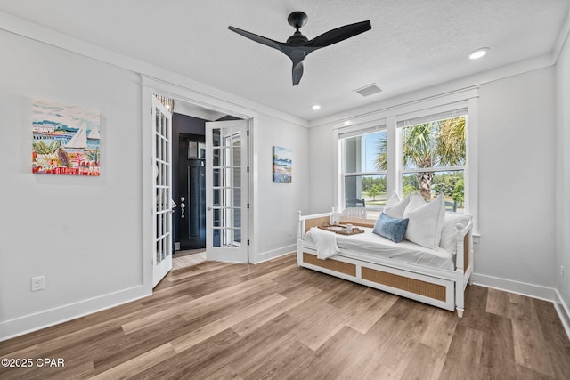 living area with ceiling fan, french doors, wood finished floors, and baseboards