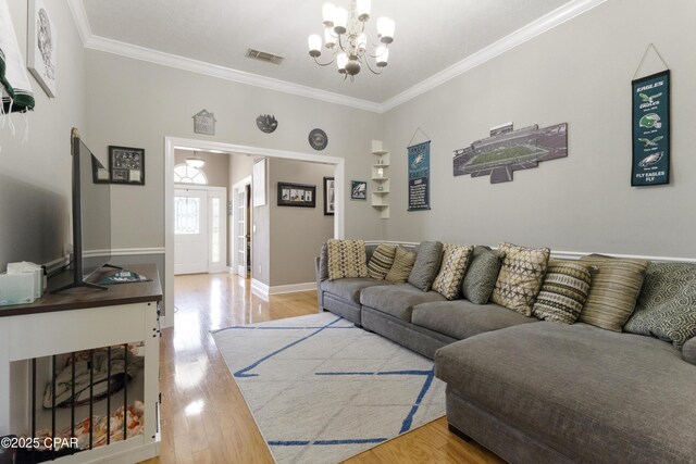 924 N College Blvd, Lynn Haven, FL 32444 - living room featuring an inviting chandelier, wood finished floors, visible vents, and ornamental molding