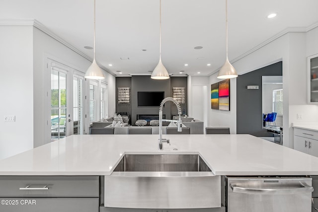 kitchen with a sink, open floor plan, light countertops, stainless steel dishwasher, and an island with sink