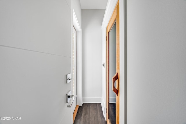 hall with baseboards and dark wood-type flooring