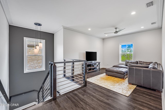 living area with wood finished floors, visible vents, recessed lighting, and crown molding