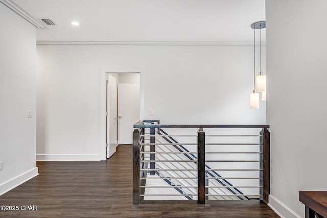 hall with baseboards, visible vents, and ornamental molding