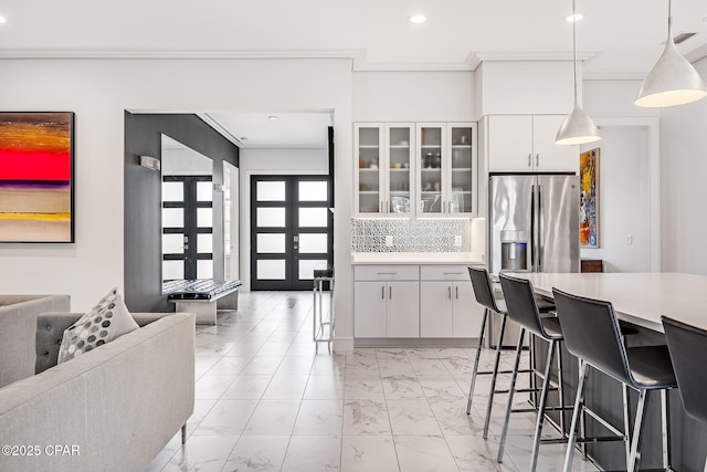 kitchen featuring light countertops, ornamental molding, and marble finish floor