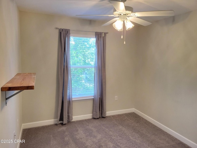carpeted spare room with a ceiling fan and baseboards