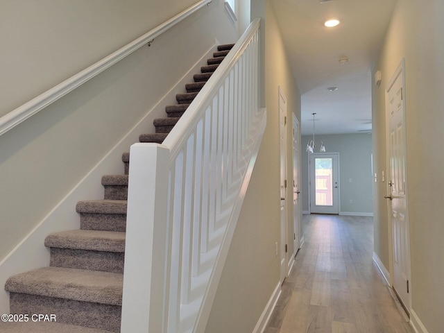 staircase with baseboards, recessed lighting, and wood finished floors