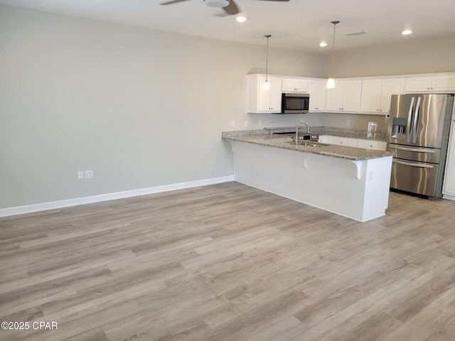 kitchen featuring stainless steel appliances, a ceiling fan, white cabinetry, baseboards, and a peninsula