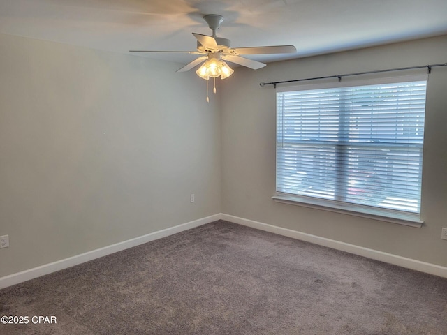carpeted spare room featuring baseboards, plenty of natural light, and ceiling fan