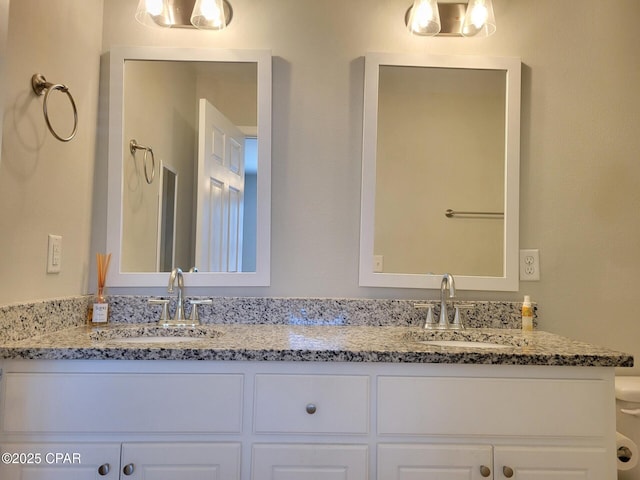 bathroom featuring a sink, toilet, and double vanity