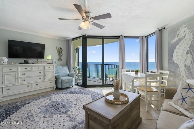 9850 S Thomas Dr Unit 810E, Panama City, FL 32408 - living room featuring a water view, light tile patterned floors, ceiling fan, ornamental molding, and a textured ceiling