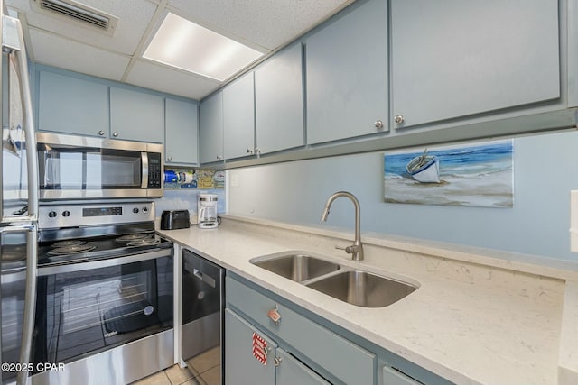 9850 S Thomas Dr Unit 810E, Panama City, FL 32408 - kitchen with stainless steel appliances, a sink, gray cabinets, light stone countertops, and light tile patterned floors