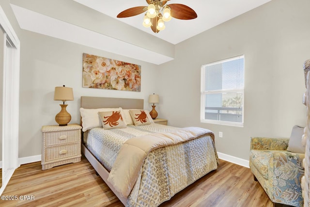 bedroom with baseboards, light wood finished floors, and ceiling fan