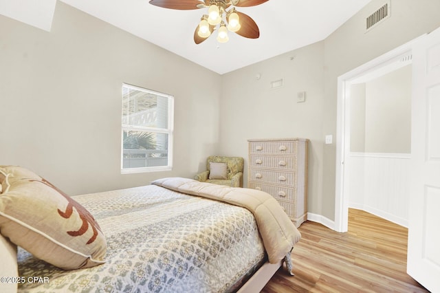 bedroom with light wood-style flooring, ceiling fan, and baseboards