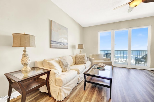 living room with wood finished floors, a ceiling fan, and a water view