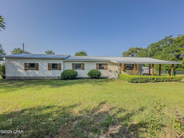 view of front facade featuring metal roof and a front yard
