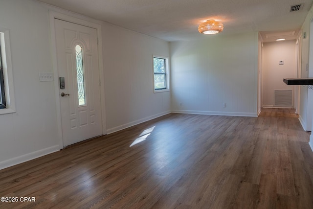 foyer featuring baseboards, visible vents, and wood finished floors