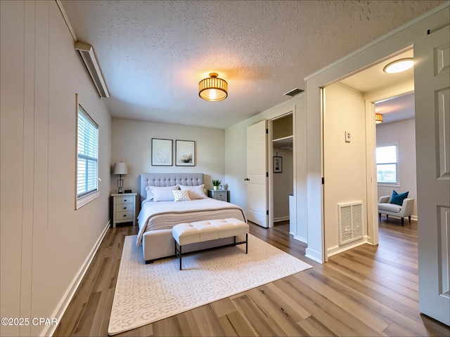 bedroom featuring visible vents, baseboards, and wood finished floors