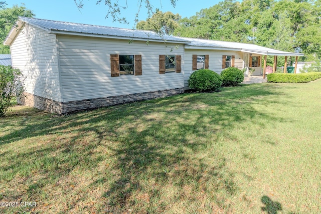 back of property with covered porch, a yard, and metal roof