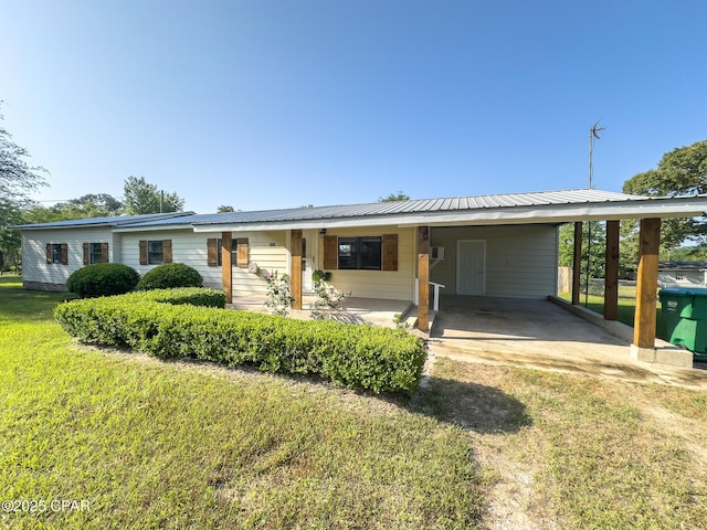 ranch-style house with metal roof, driveway, a front yard, and a carport