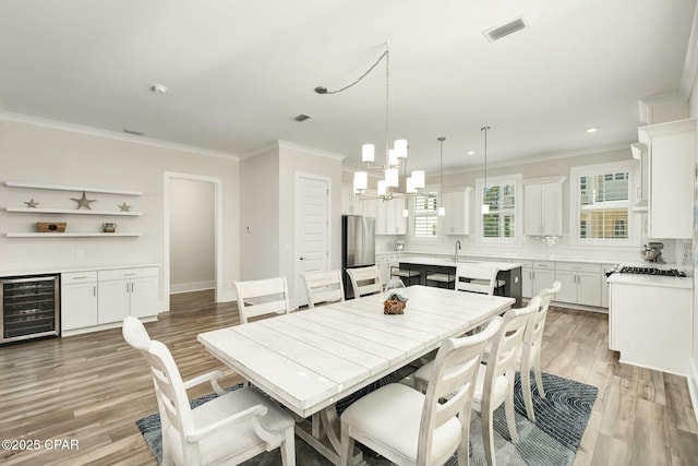 19 Mckenna Way, Santa Rosa Beach, FL 32459 - dining space featuring crown molding, a notable chandelier, visible vents, and beverage cooler