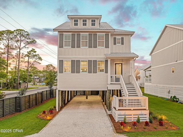 19 Mckenna Way, Santa Rosa Beach, FL 32459 - raised beach house featuring a front yard, metal roof, a carport, board and batten siding, and gravel driveway