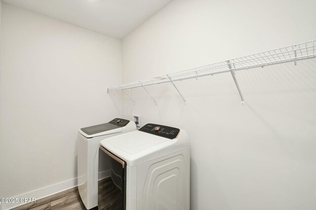 19 Mckenna Way, Santa Rosa Beach, FL 32459 - clothes washing area featuring baseboards, wood finished floors, washing machine and clothes dryer, and laundry area