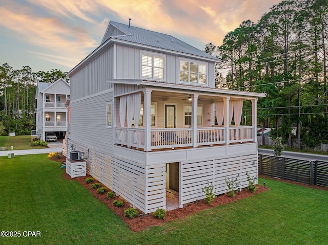 19 Mckenna Way, Santa Rosa Beach, FL 32459 - back of house at dusk with fence, board and batten siding, and a yard