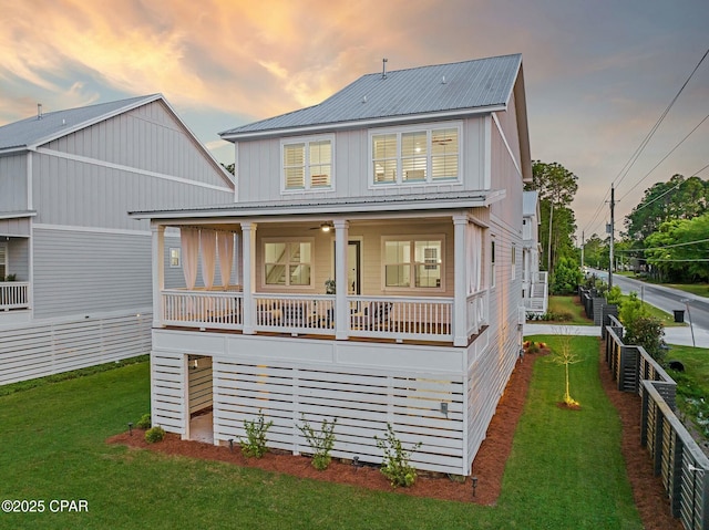 19 Mckenna Way, Santa Rosa Beach, FL 32459 - rear view of property featuring board and batten siding, metal roof, fence, a yard, and a porch