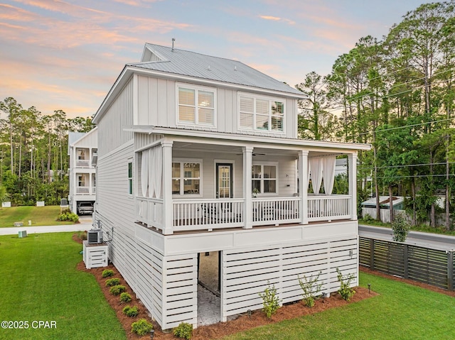 19 Mckenna Way, Santa Rosa Beach, FL 32459 - rear view of house with a porch, metal roof, a lawn, board and batten siding, and fence