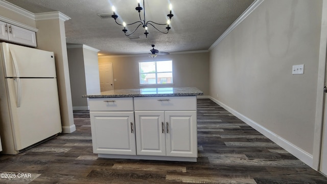 kitchen with freestanding refrigerator, white cabinetry, a notable chandelier, a textured ceiling, and dark wood-type flooring