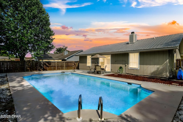 pool at dusk with a patio, a fenced in pool, and a fenced backyard
