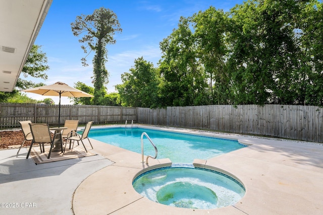 view of pool with a fenced backyard, a pool with connected hot tub, and a patio area