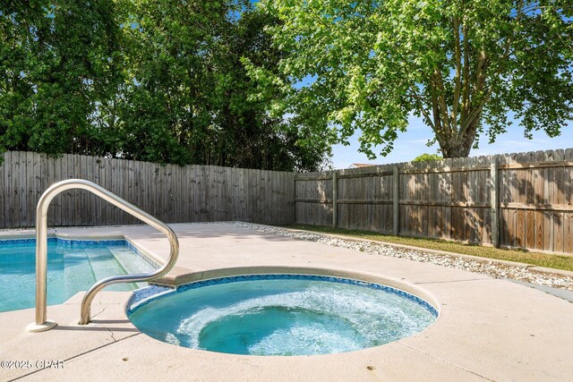 pool with an in ground hot tub and a fenced backyard
