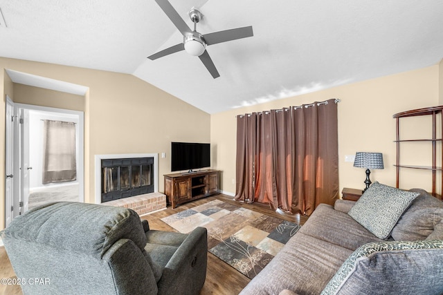 living room with wood finished floors, a ceiling fan, lofted ceiling, and a fireplace