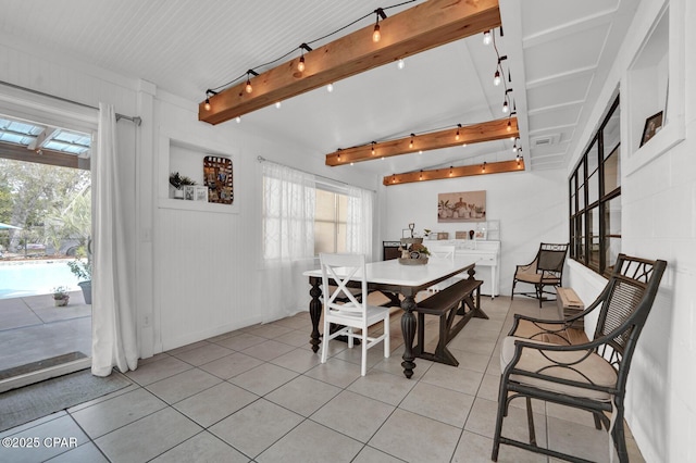 dining room with track lighting, light tile patterned floors, and beam ceiling