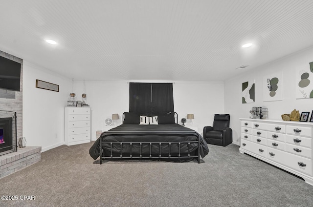 carpeted bedroom with a brick fireplace, recessed lighting, visible vents, and baseboards