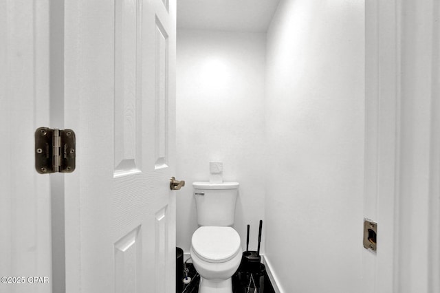 bathroom with toilet and baseboards