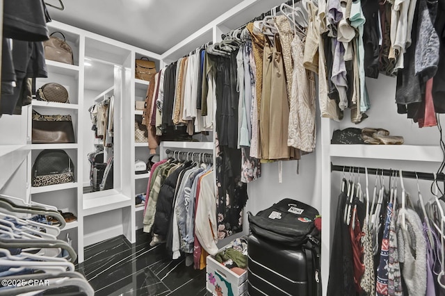 walk in closet featuring marble finish floor