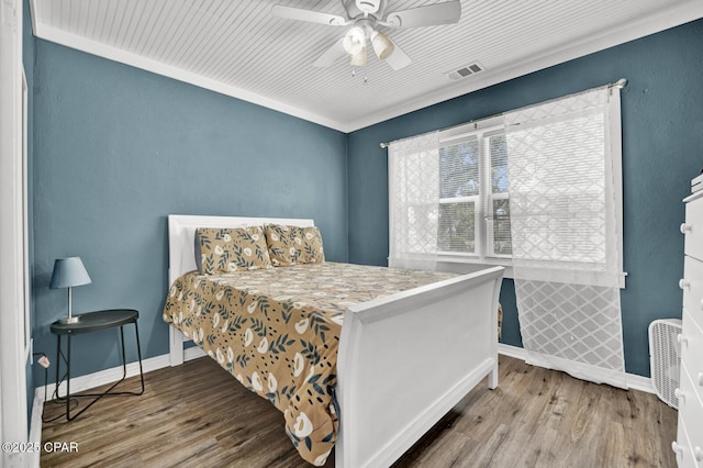 bedroom featuring baseboards, visible vents, wood finished floors, and ceiling fan