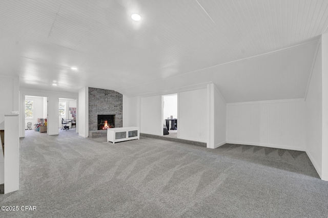 bonus room featuring baseboards, carpet floors, lofted ceiling, and a fireplace