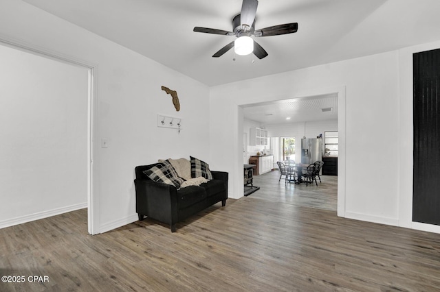 sitting room featuring baseboards, wood finished floors, and ceiling fan