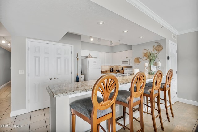 14701 Front Beach Rd Unit 834, Panama City Beach, FL 32413 - kitchen with white appliances, light tile patterned flooring, baseboards, white cabinets, and ornamental molding