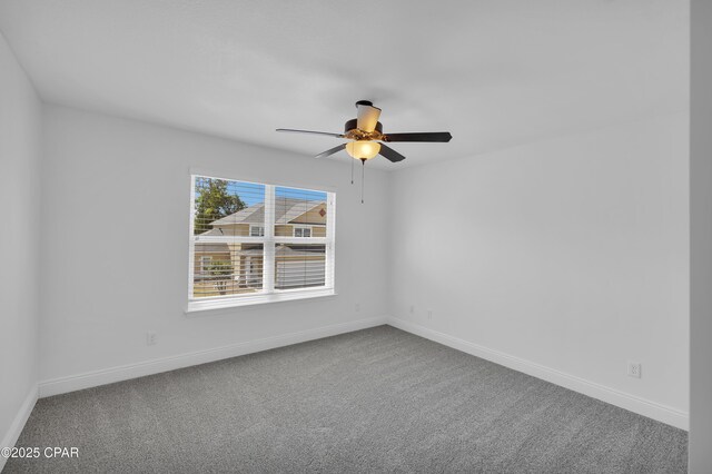 unfurnished room with carpet flooring, a ceiling fan, and baseboards