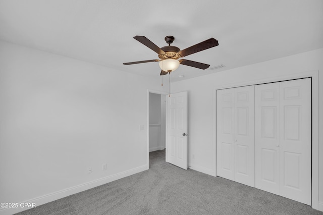 unfurnished bedroom featuring baseboards, carpet flooring, a ceiling fan, and a closet