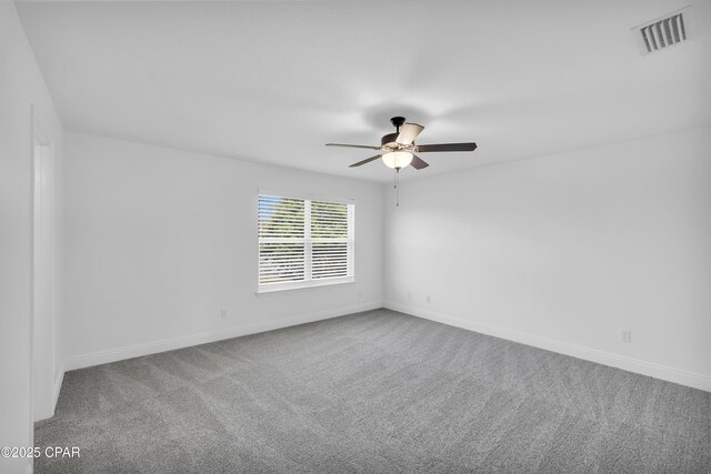 unfurnished room with carpet flooring, a ceiling fan, baseboards, and visible vents