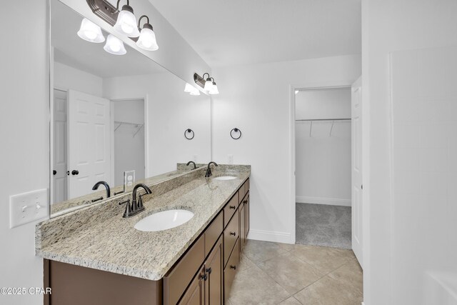 full bathroom with a sink, a walk in closet, and double vanity