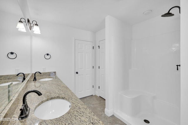bathroom with double vanity, tile patterned floors, a sink, and a shower