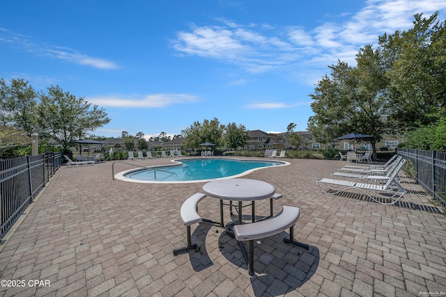 community pool with fence and a patio