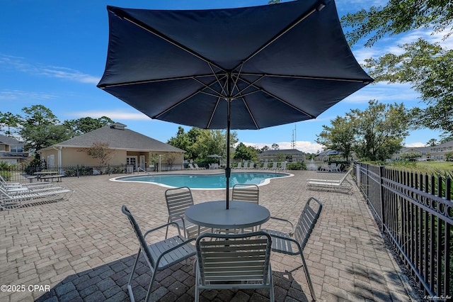 community pool featuring a patio and fence