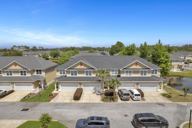 view of front of home with a residential view, a shingled roof, a garage, a water view, and driveway